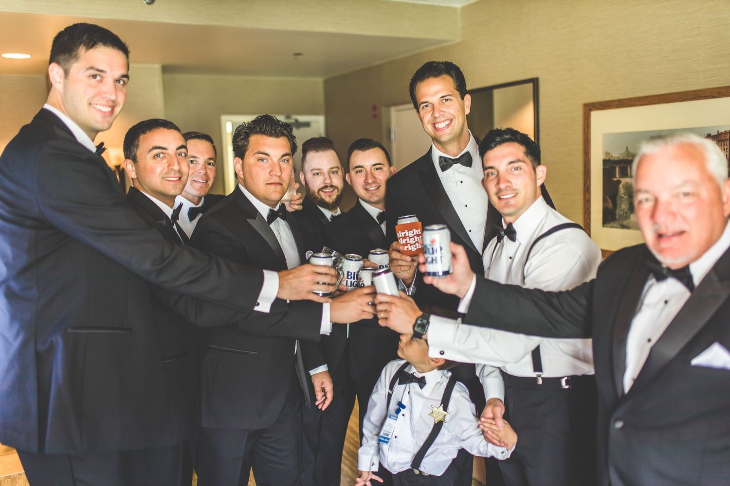 Groomsmen in black tuxedos gather for candid moments before ceremony.