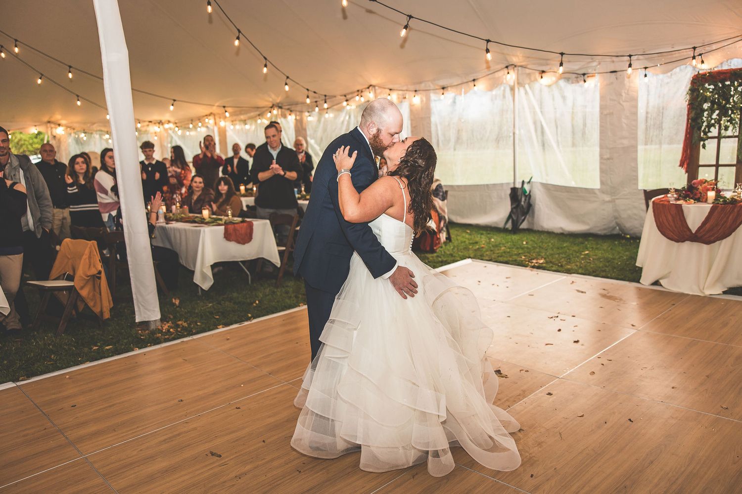 Wedding reception dance captured in sequence under romantic tent lighting with guests watching.