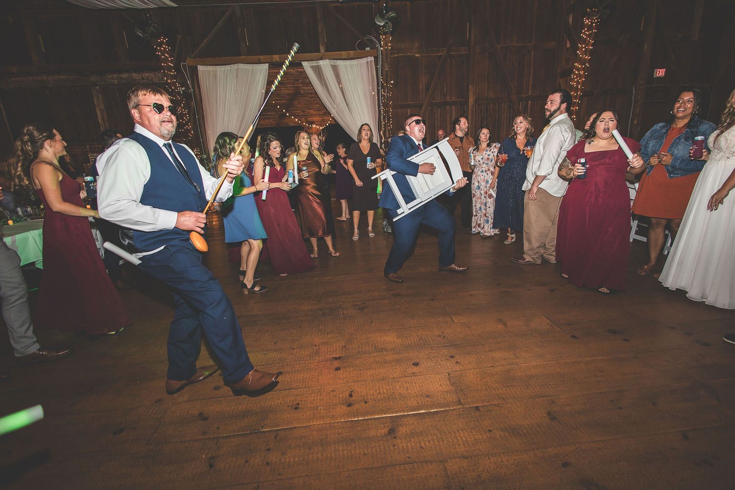 Wedding guests dancing on wooden floors during an evening reception celebration.