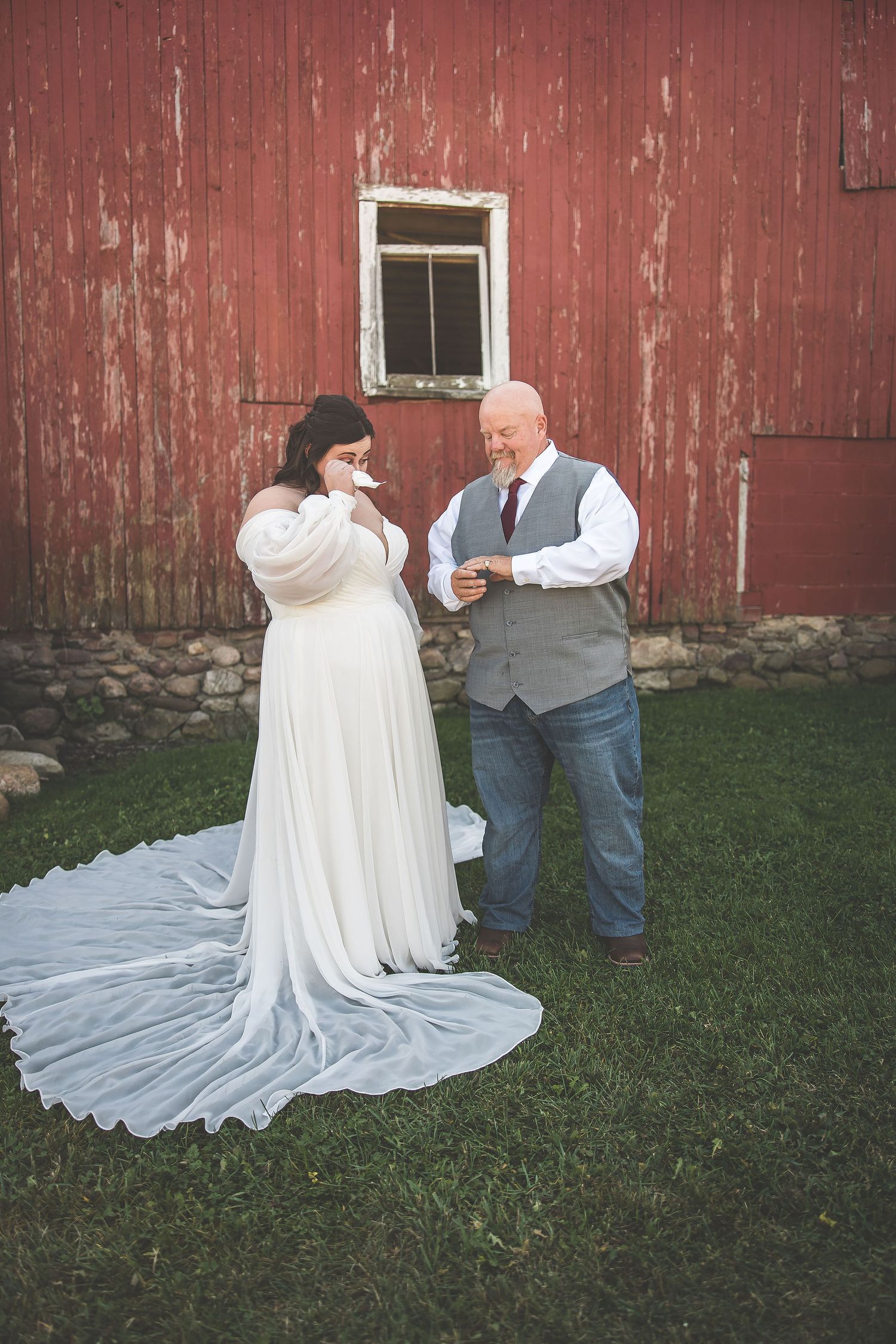 Wedding couple shares intimate moments during their photoshoot by a red barn.