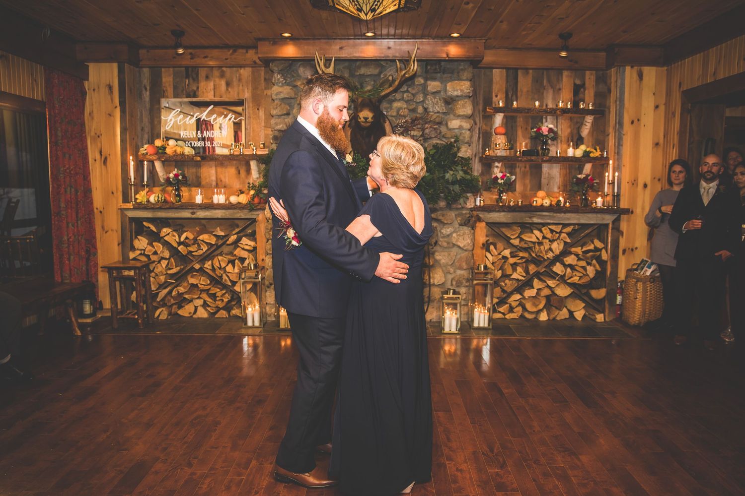 Wedding celebration features dancing in a warmly lit rustic venue with wooden details.