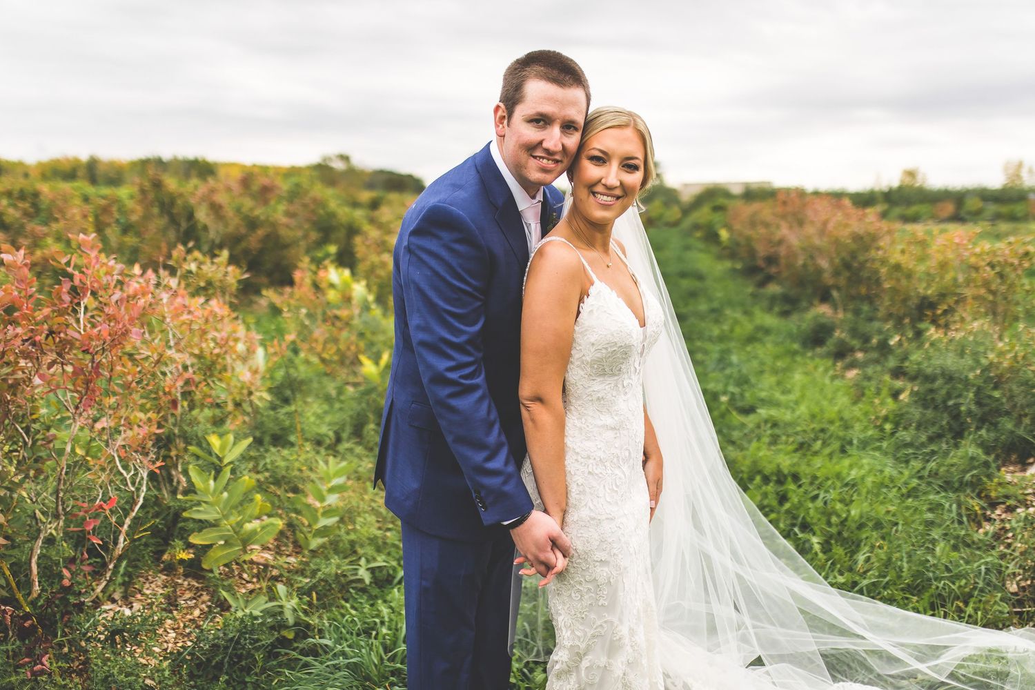 Joyful wedding portraits captured in vibrant outdoor garden setting with natural light.
