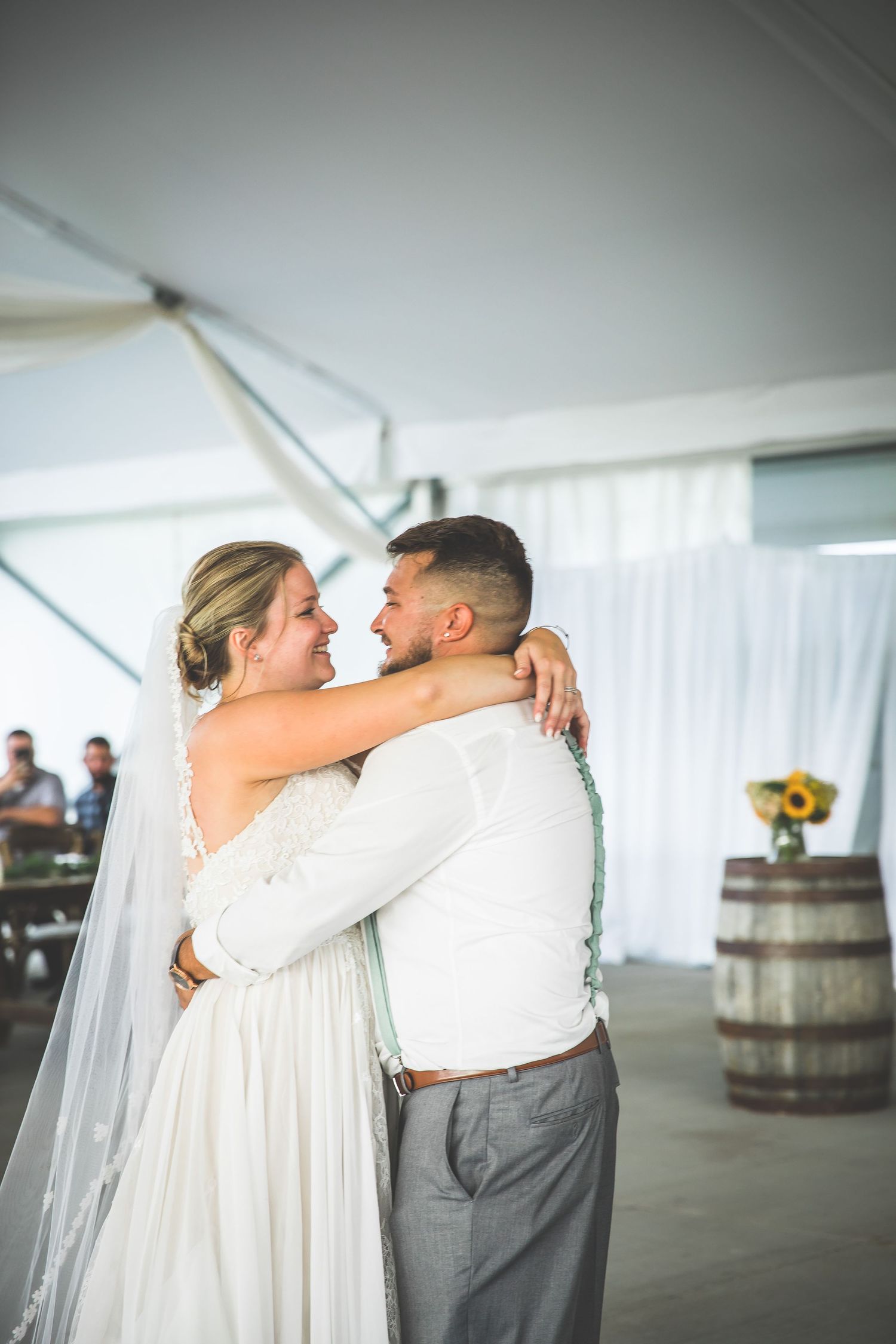 First dance moments captured in a white tent reception space with romantic lighting.