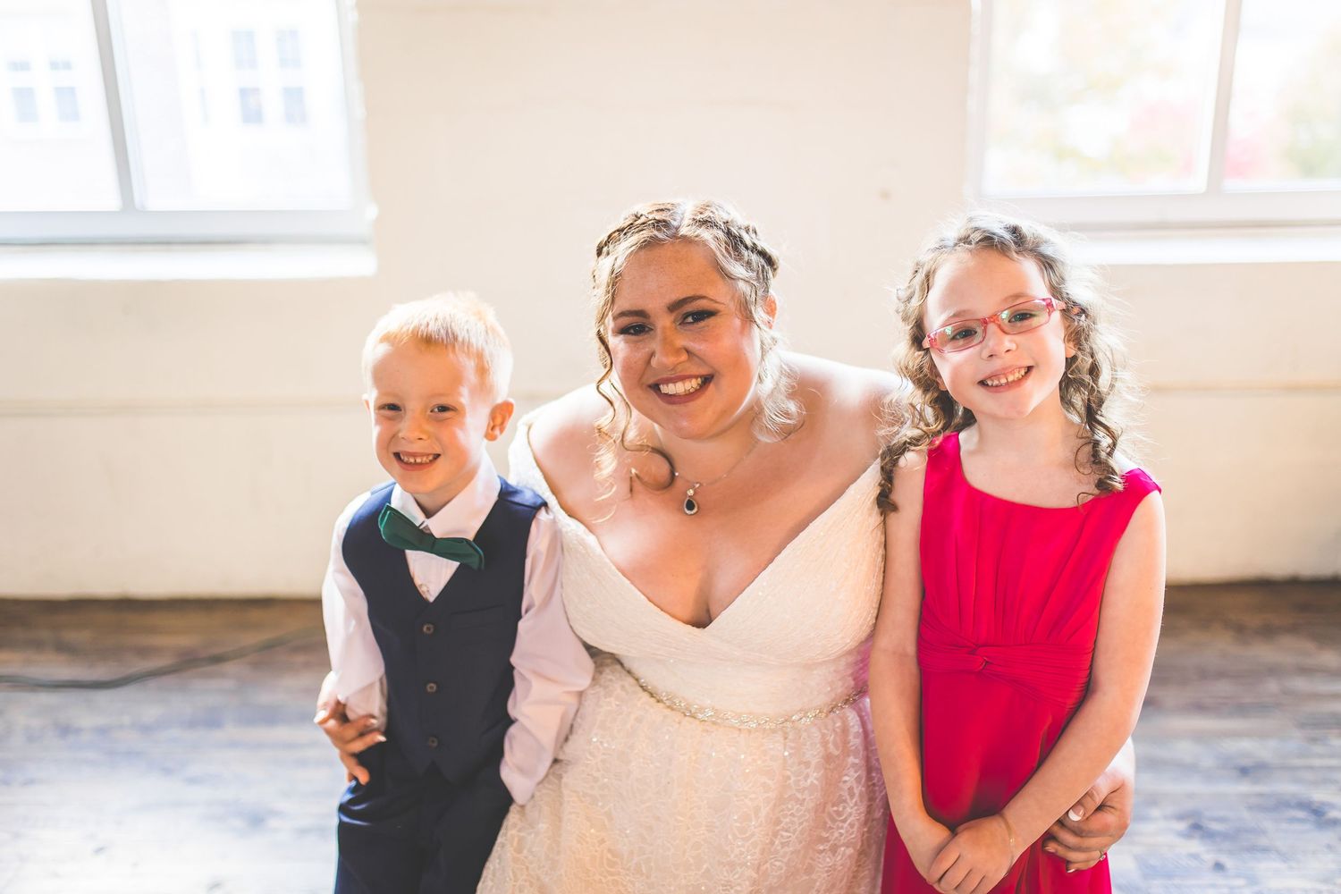 Wedding party members posing together in a bright indoor setting.