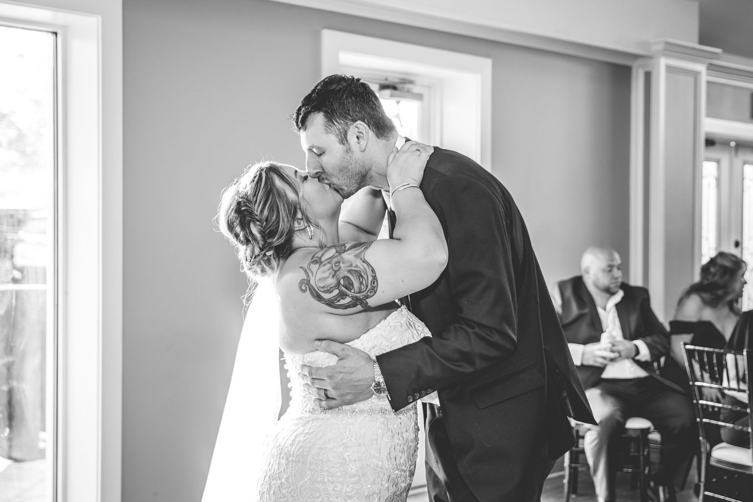 Natural light streams through windows during tender wedding moments in black and white.