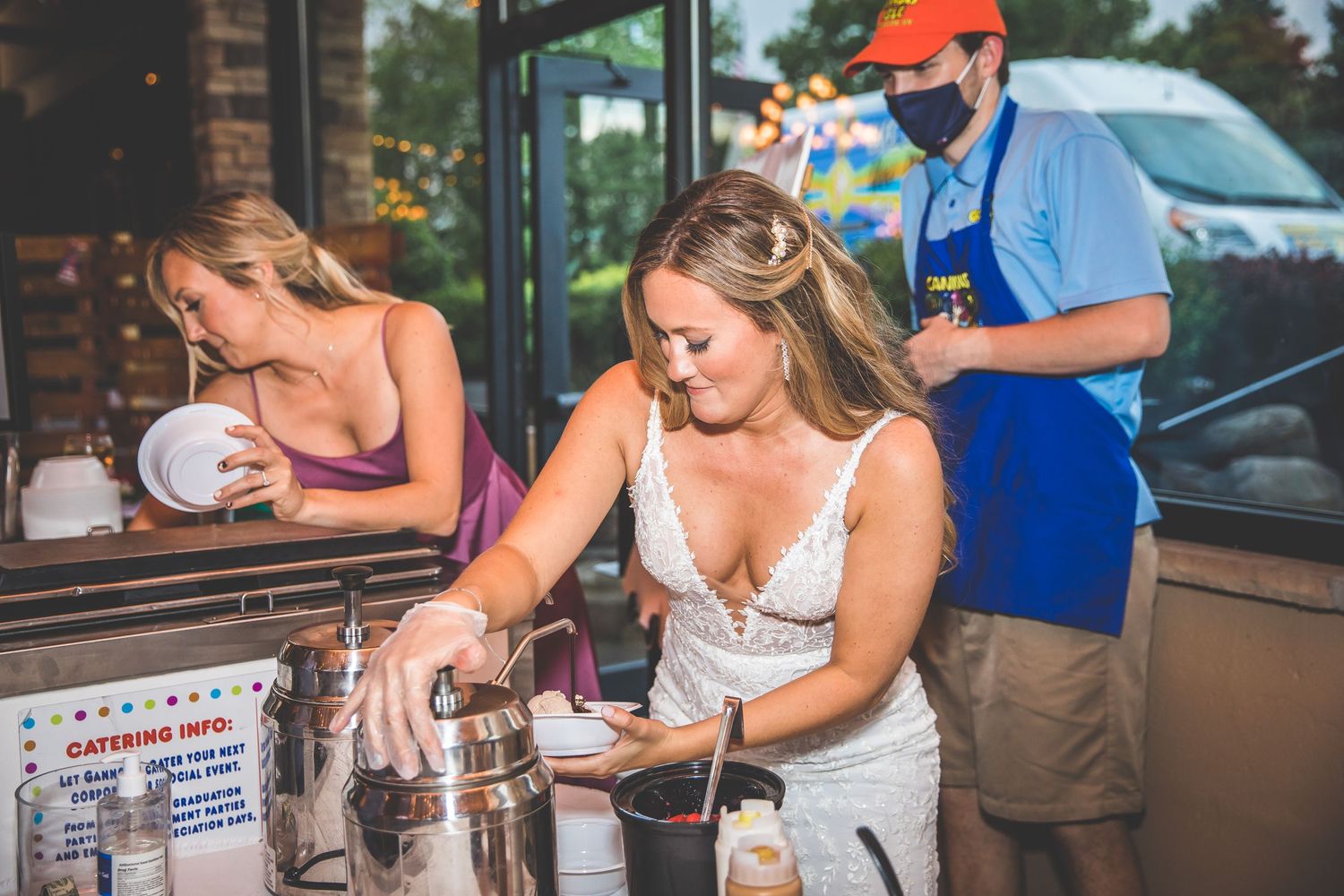 A bride prepares drinks at a wedding reception bar area.