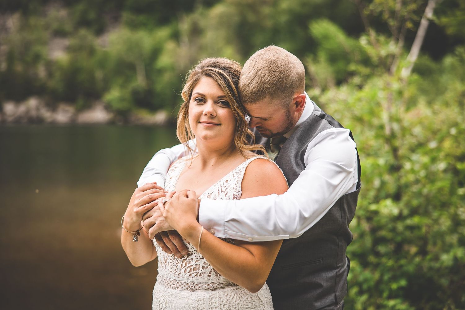 An intimate moment between newlyweds captured by a peaceful lake.