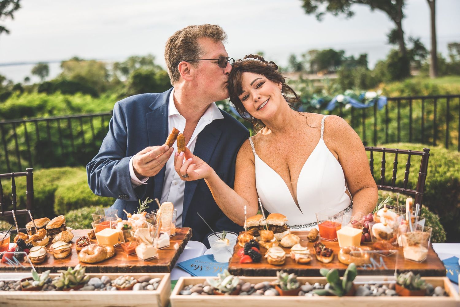 Wedding reception table set with seafood and appetizers on an outdoor patio.