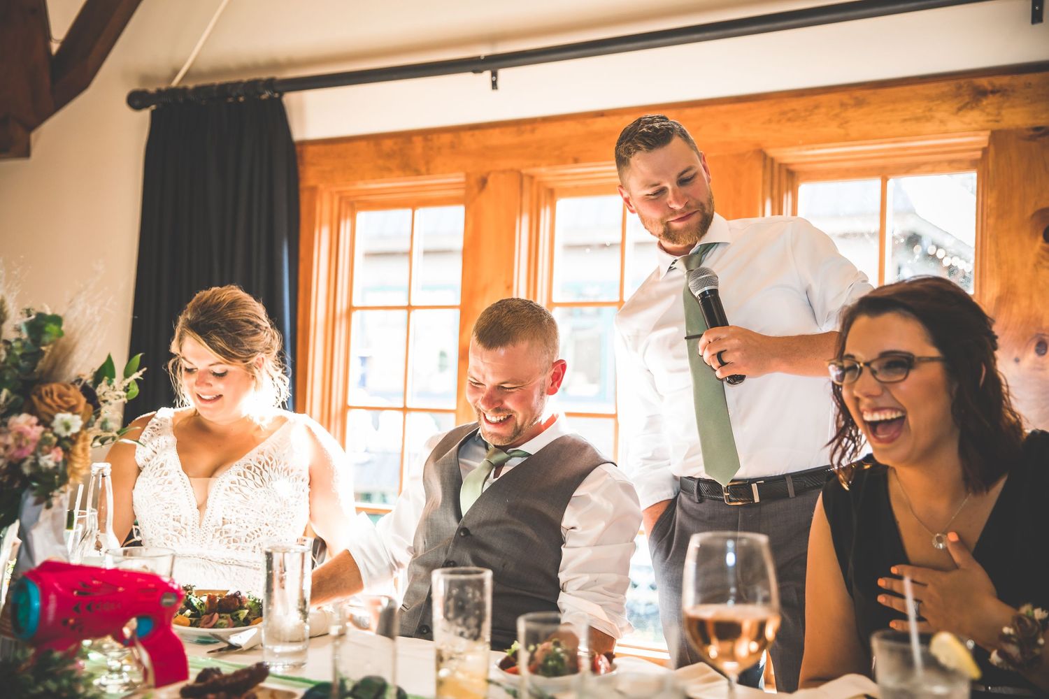 Candid moments of wedding guests laughing and celebrating at a rustic indoor venue.