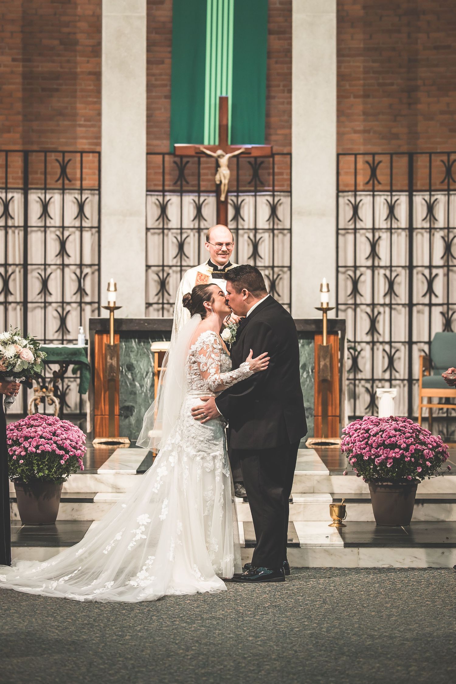 Intimate wedding moment captured at a traditional church with brick walls and decorative columns.
