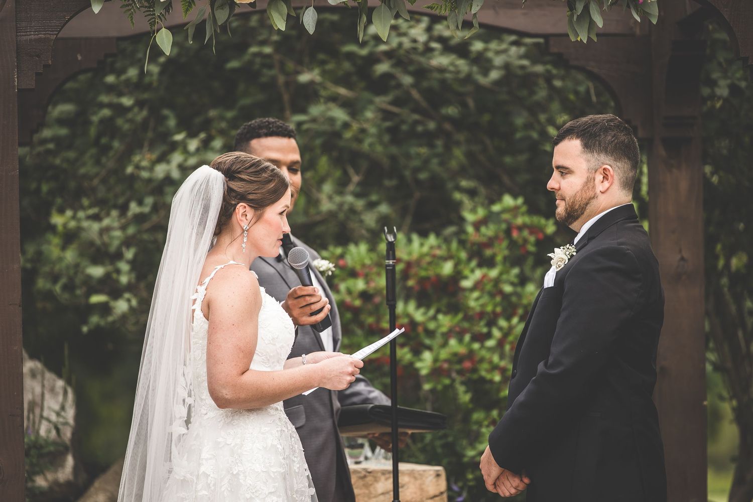 Wedding ceremony moments captured under wooden pergola with floral decorations.