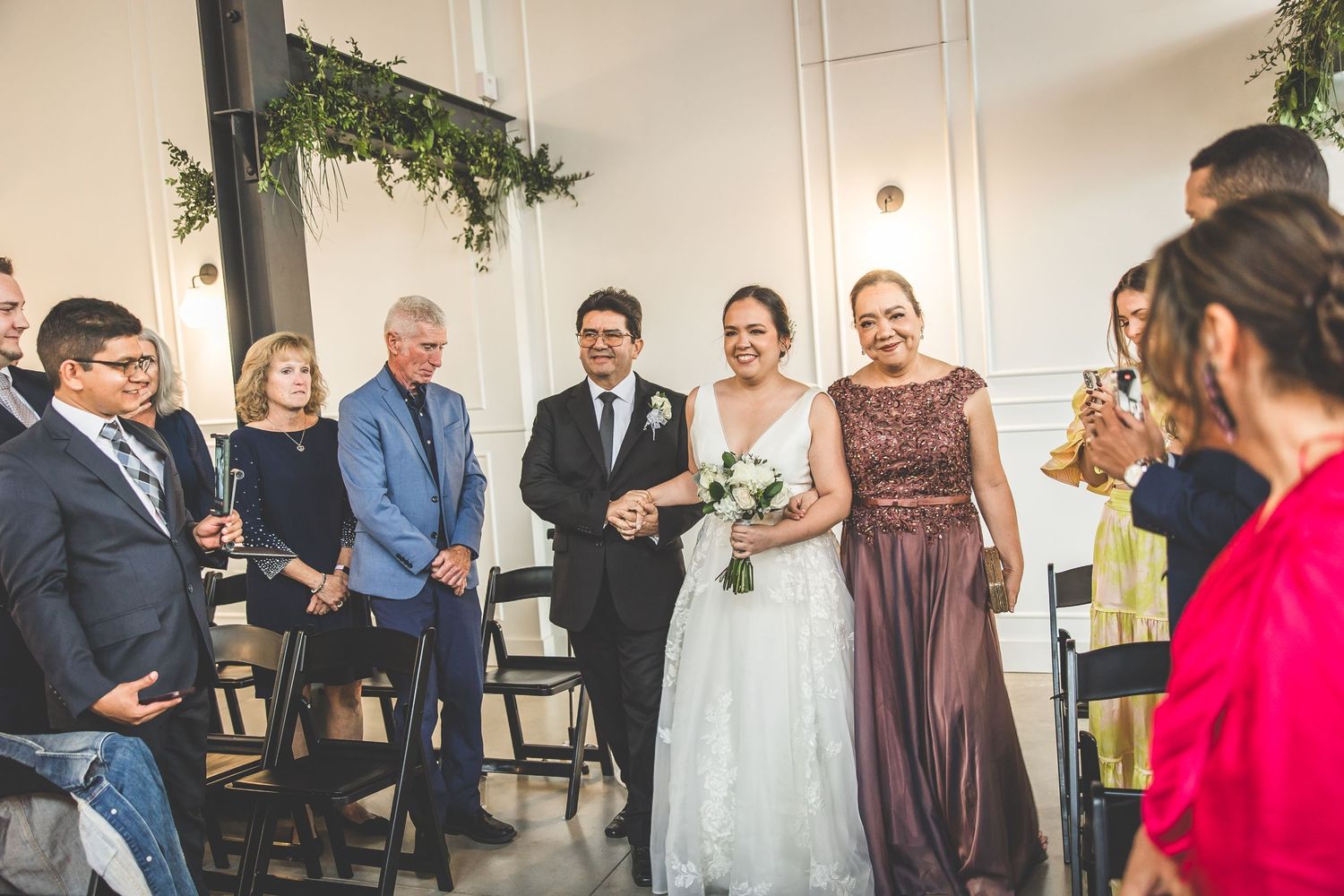 Wedding celebration candid moments captured in bright reception venue with decorative elements.