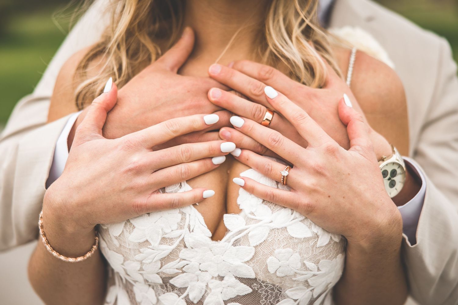 Close-up details of lace wedding dress and romantic embrace.
