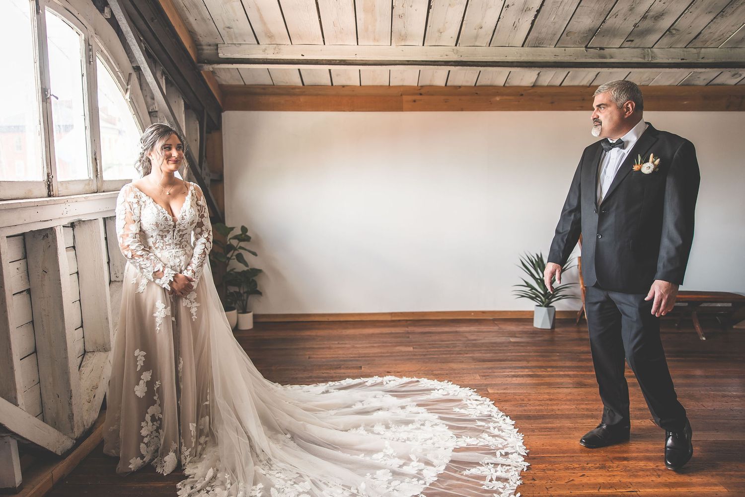 Wedding party members pose in a rustic wooden room with natural lighting.