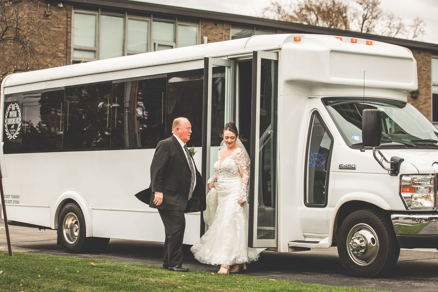 Bride and companion walking towards entrance of brick church with arched doorways.