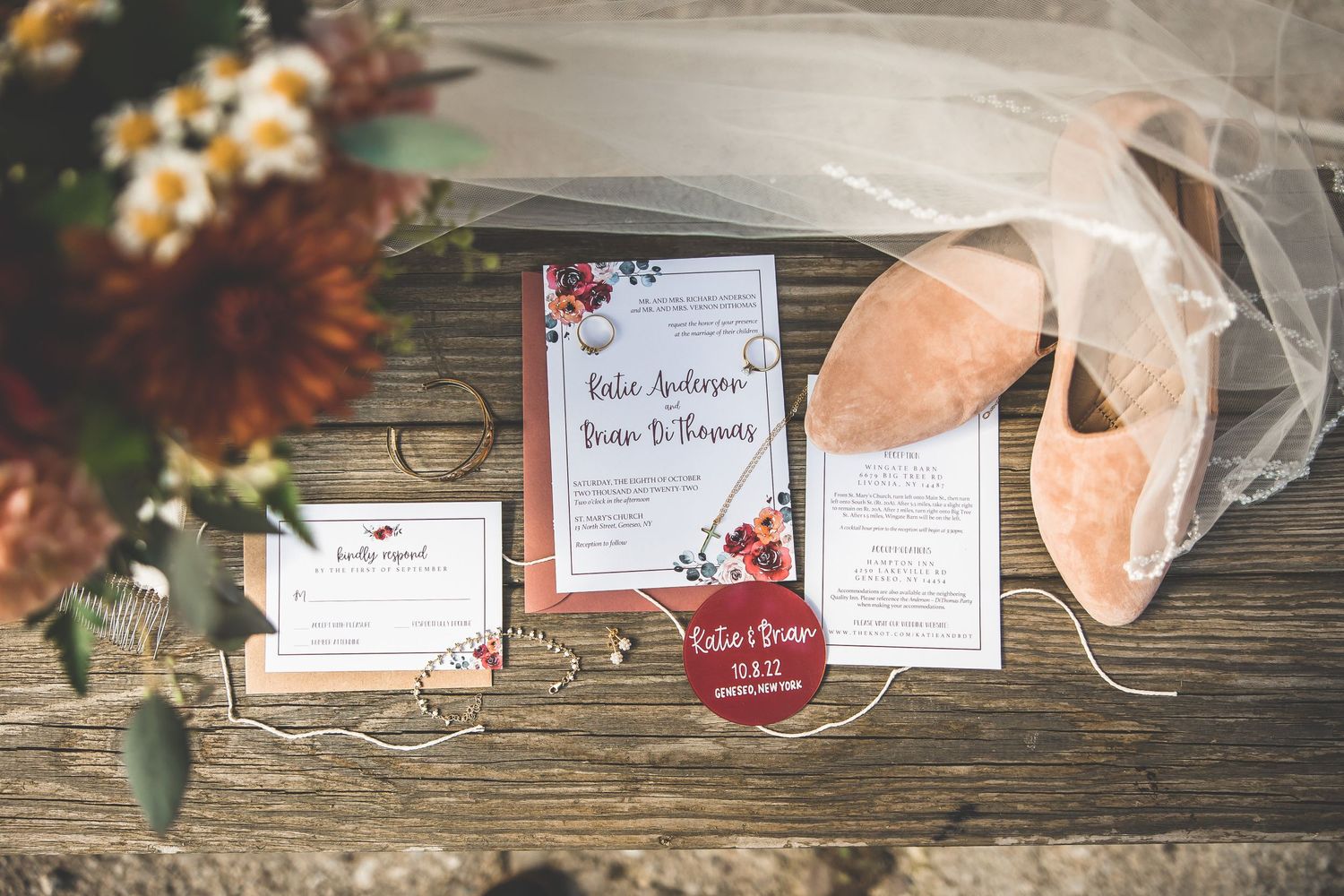 Wedding stationery and invitations displayed on rustic wooden surface.
