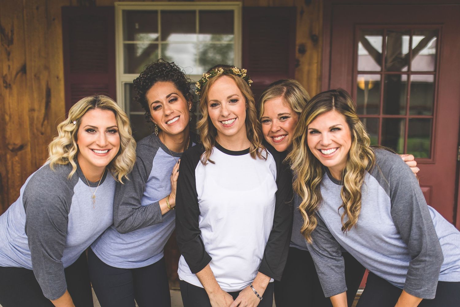 Group wearing matching gray and white shirts posing together outdoors.