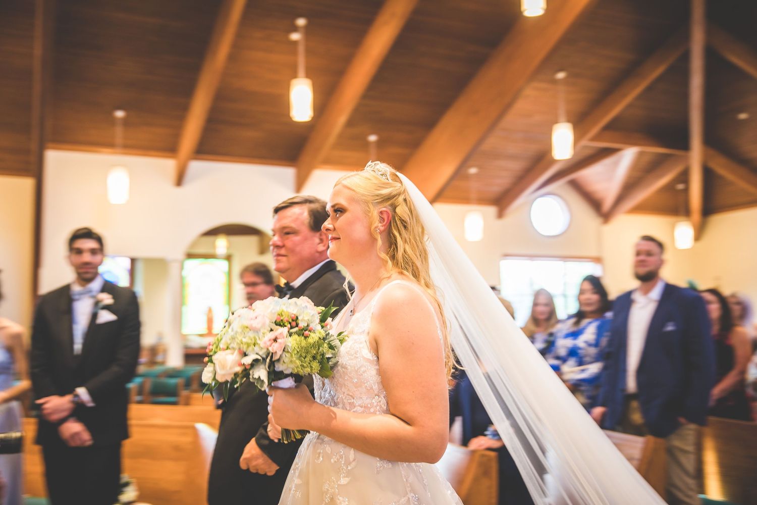 Wedding ceremony in progress inside traditional church sanctuary.