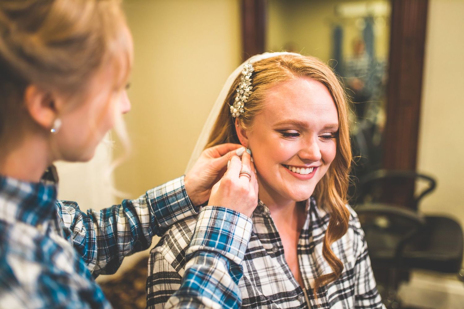 A series of joyful getting ready moments captured in soft lighting at a wedding.