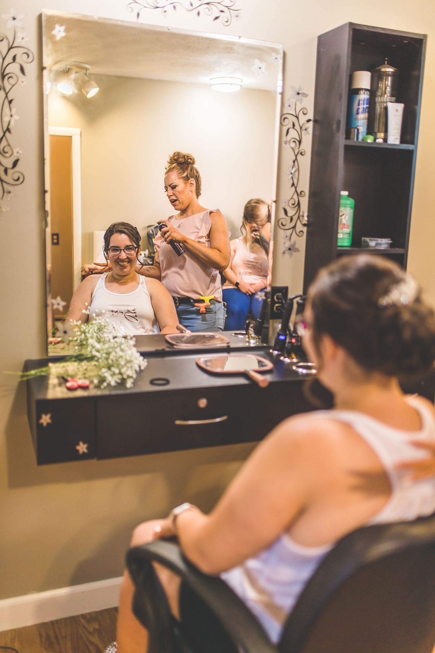 Wedding preparation scene in salon with mirrors and styling stations.