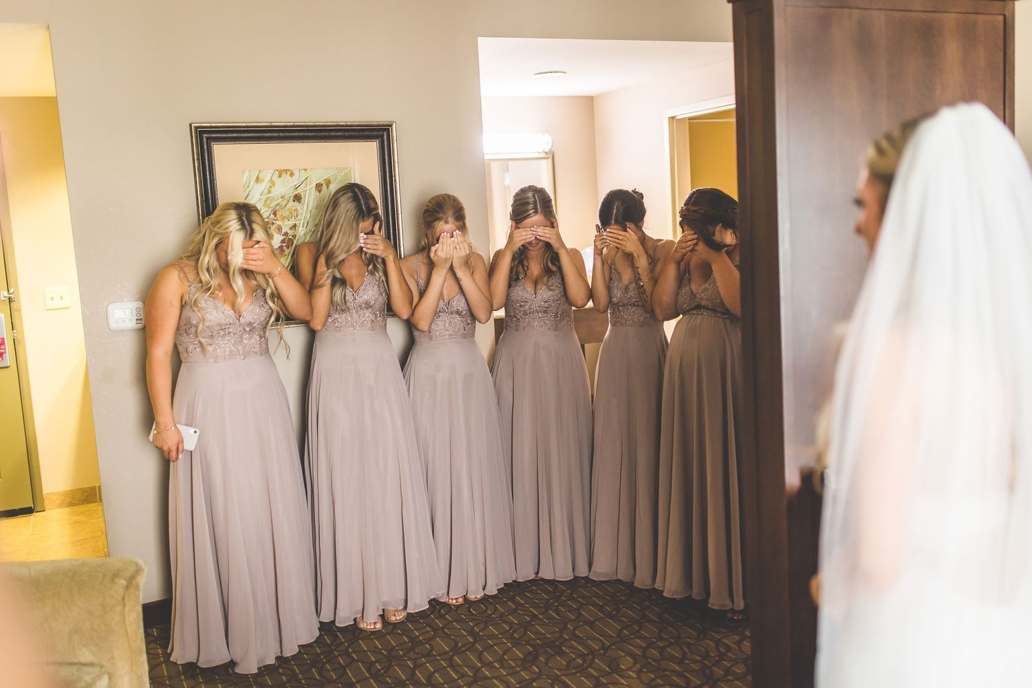 Bridesmaids in matching gray dresses lined up for a wedding photo.