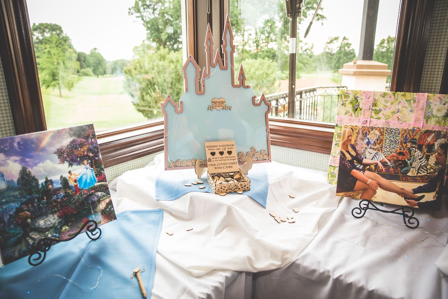 Wedding reception decor features a castle centerpiece with blue and white themed displays.