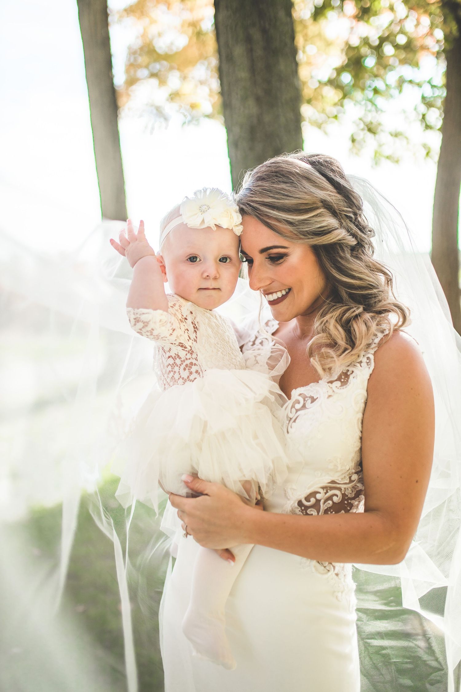 Sweet moment captured in soft sunlight through trees.