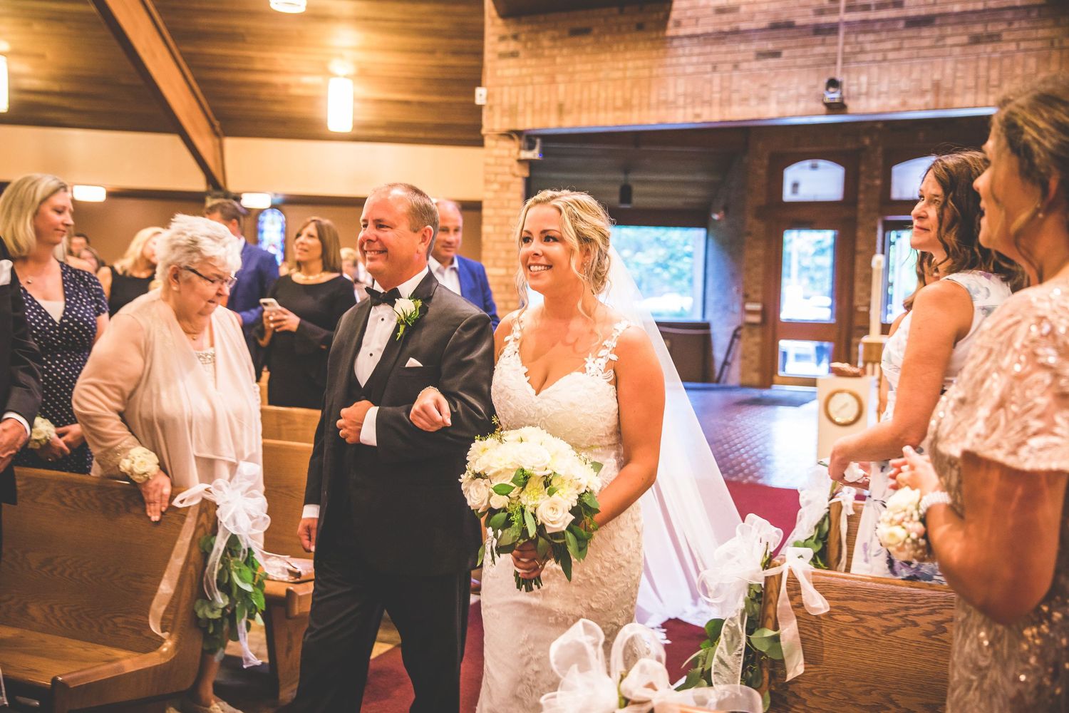 Wedding celebration in a rustic venue with exposed wooden beams and warm lighting.