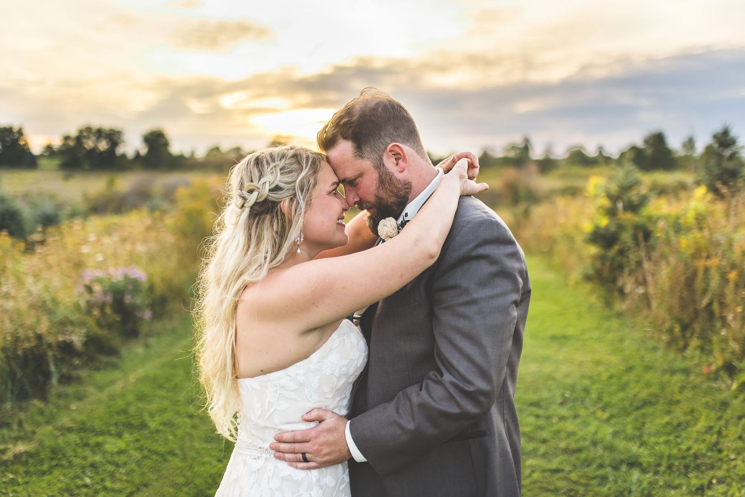 Couple embraces during golden hour photoshoot on nature path.