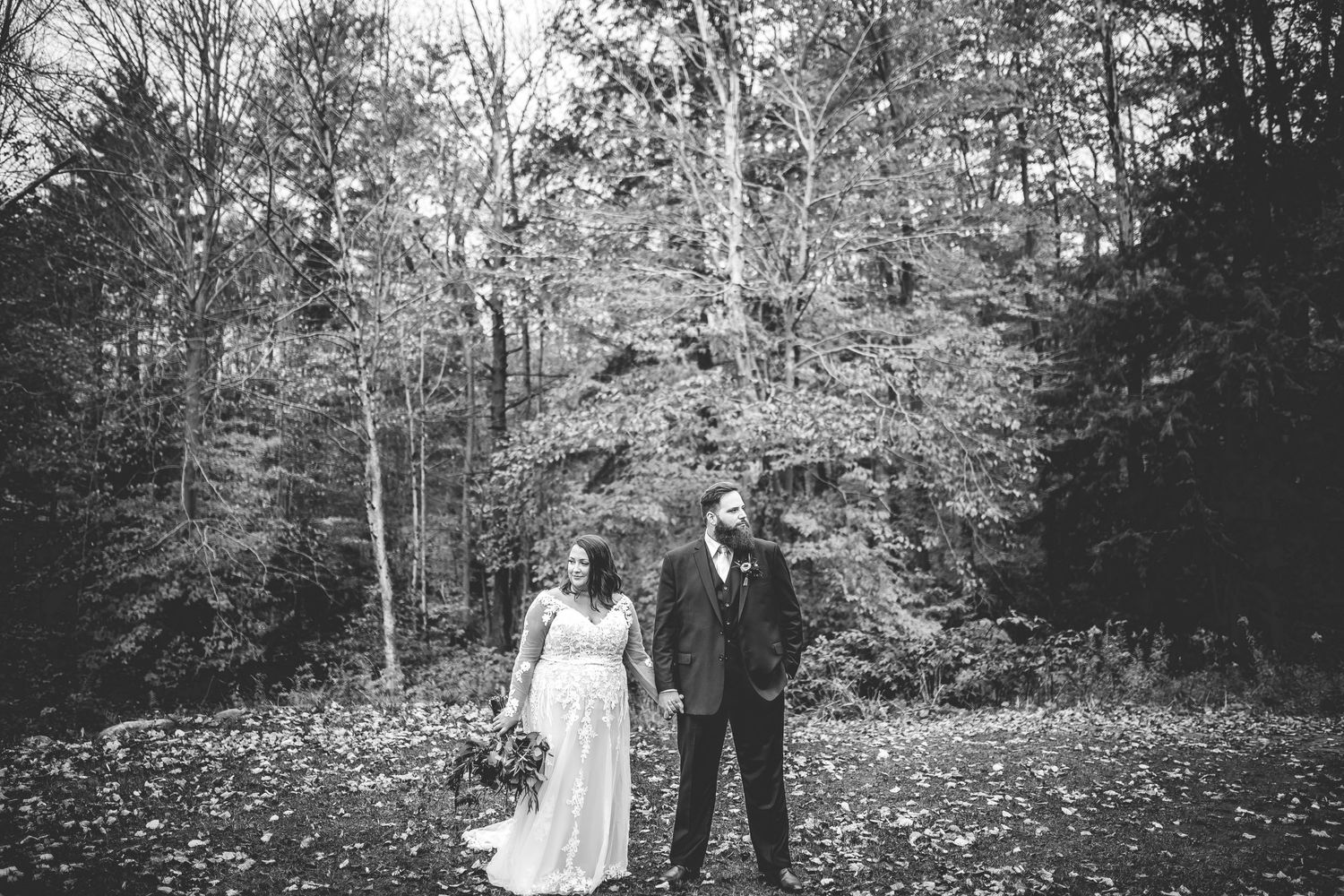 Black and white wedding photos captured in a serene forest setting.