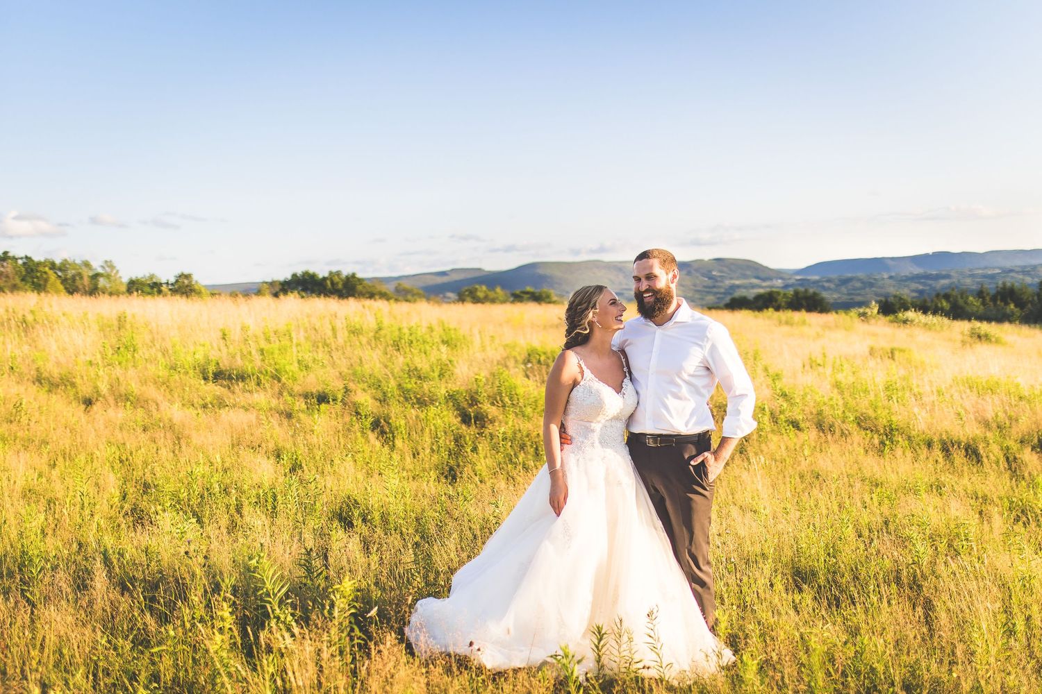 Beautiful wedding photography in a scenic mountain meadow at golden hour.
