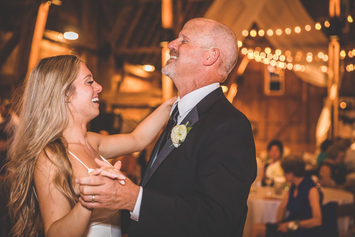 Couples dancing together during an evening wedding reception under warm lighting.