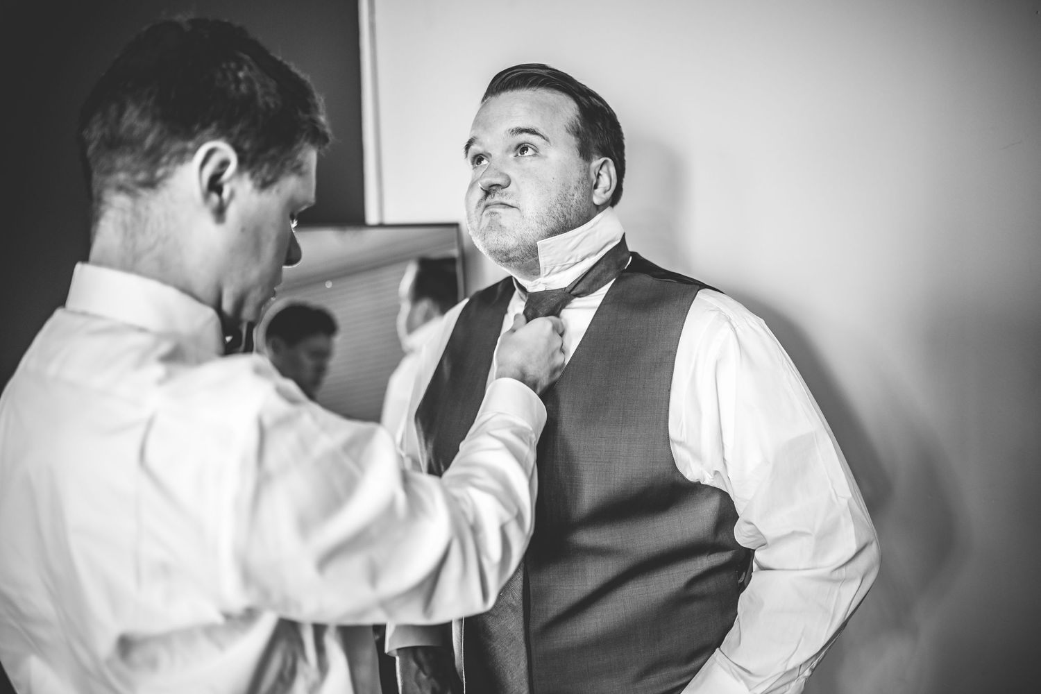Black and white photos showing preparation moments before wedding ceremony.
