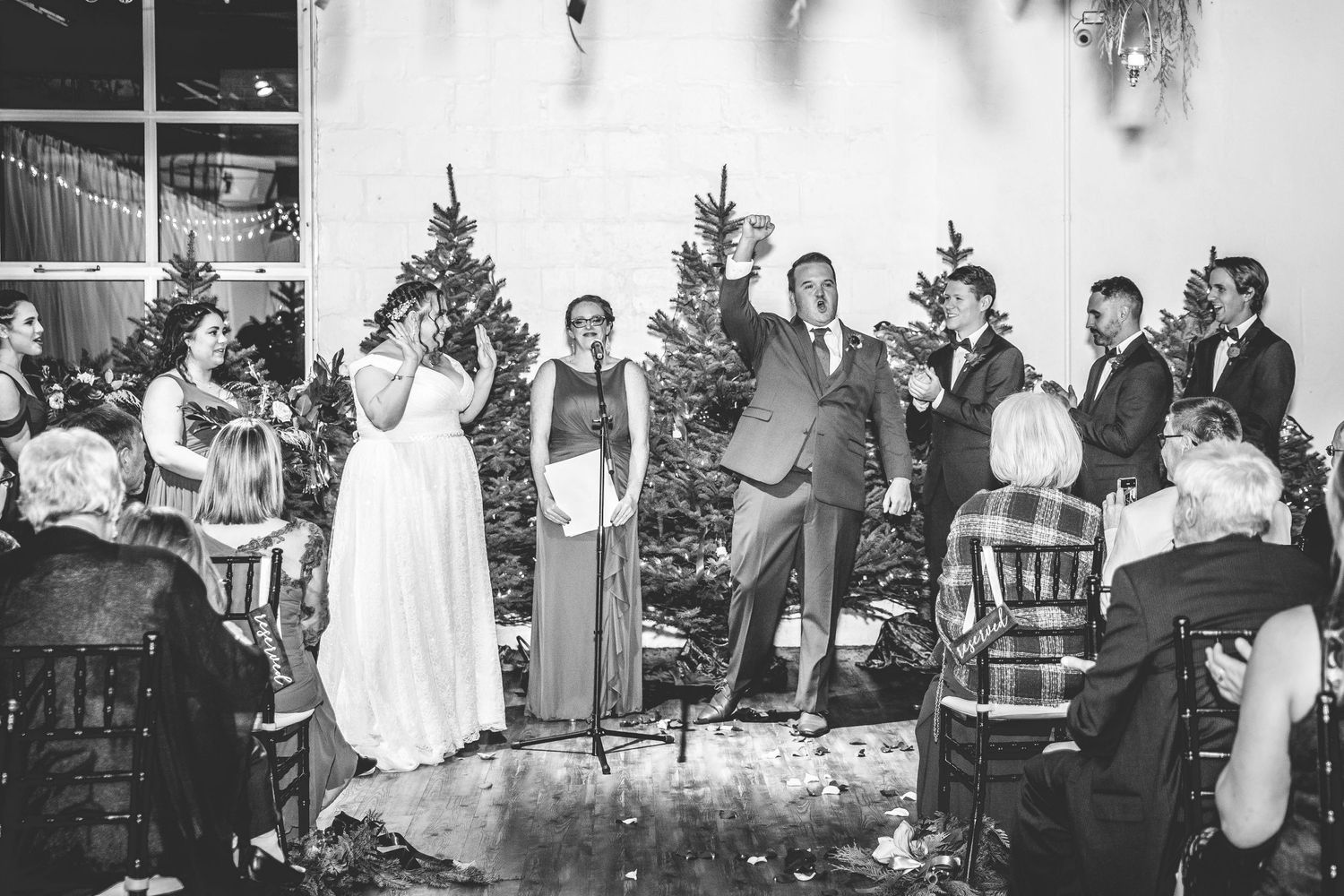 Wedding party members seated at a long table during the reception celebration.
