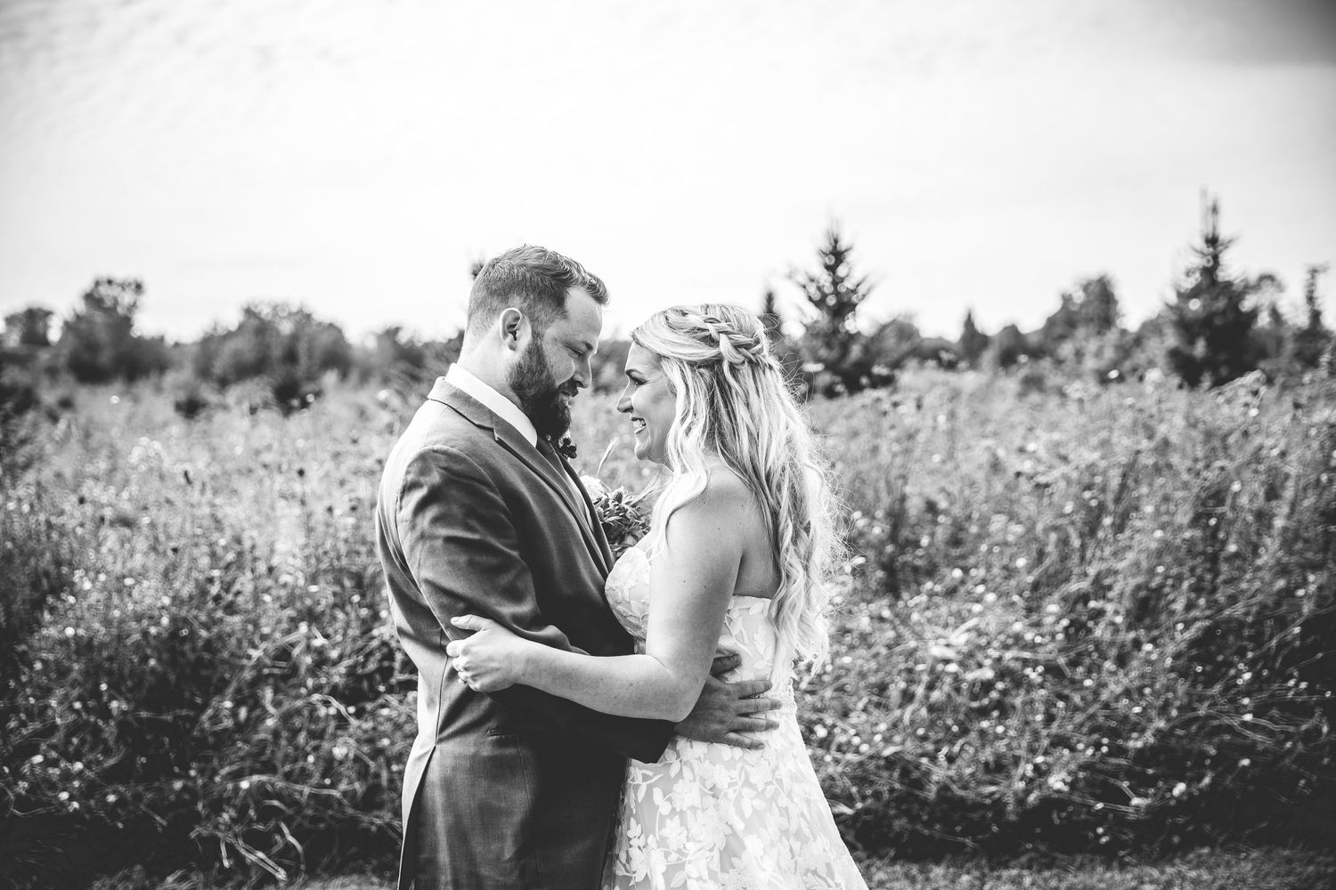 Romantic wedding photography session in a field with soft natural lighting and wildflowers.