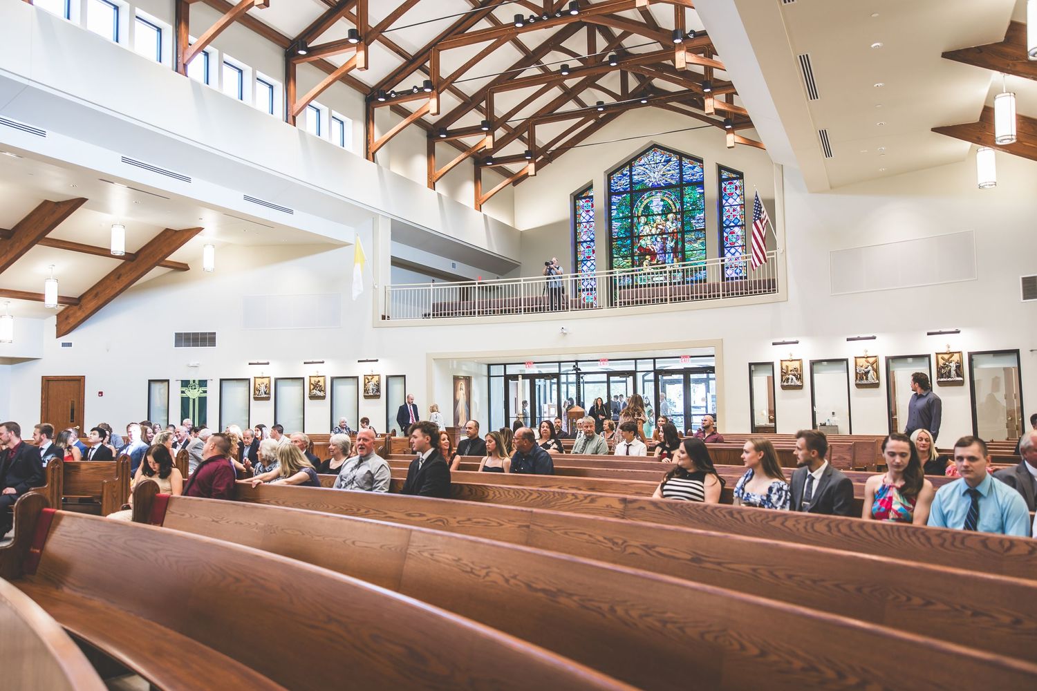 Wide angle view of a church sanctuary filled with guests during a wedding ceremony.