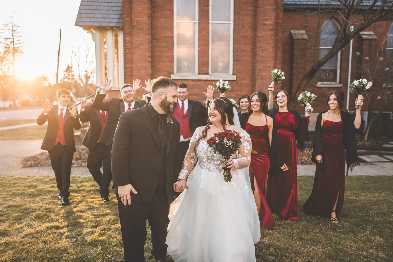 Sunset wedding portrait session with bridal party outside traditional brick church.