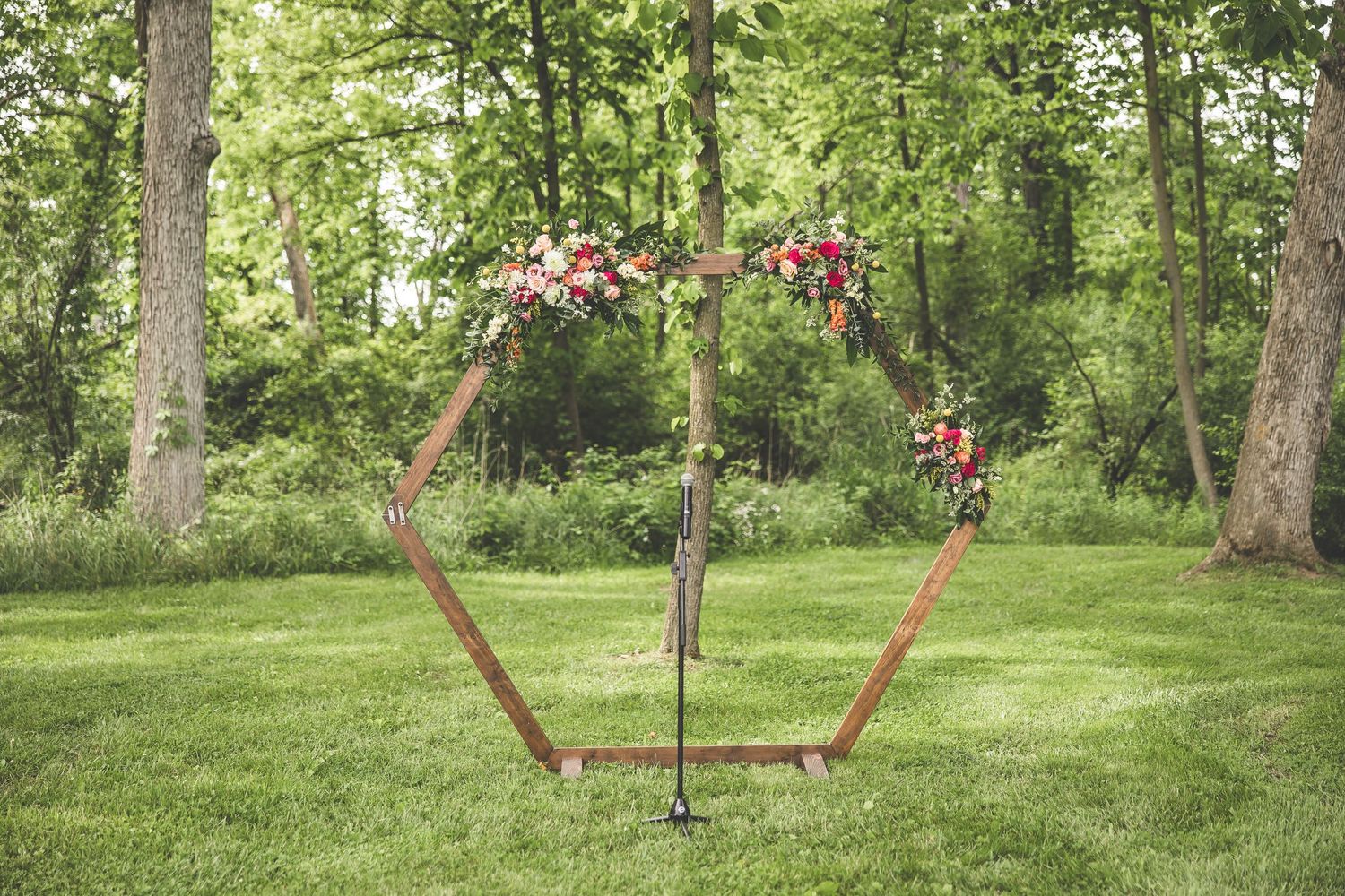 Outdoor garden wedding venue with lush green trees and natural landscaping.