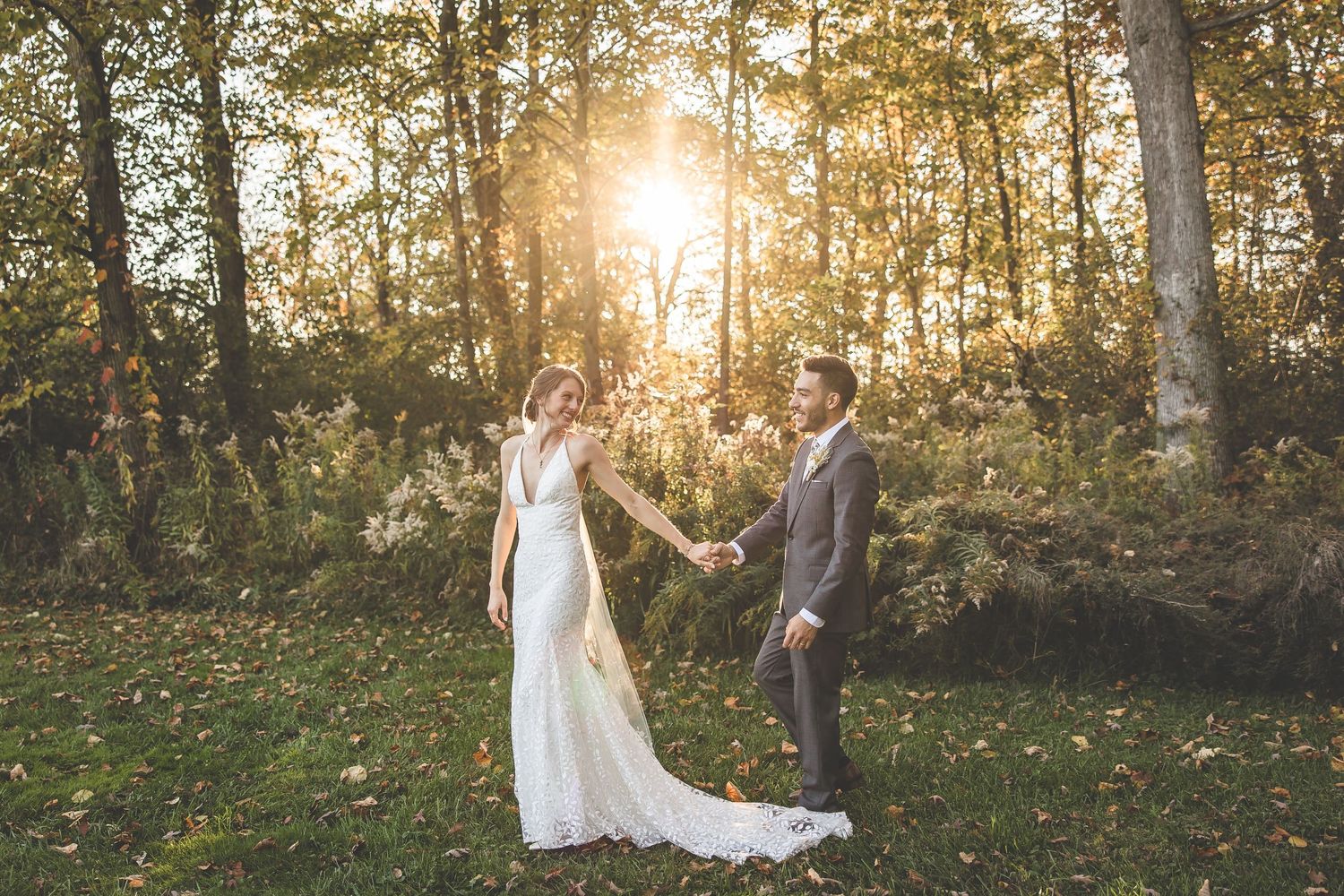 Romantic outdoor wedding photo session at sunset with trees creating a golden backdrop.