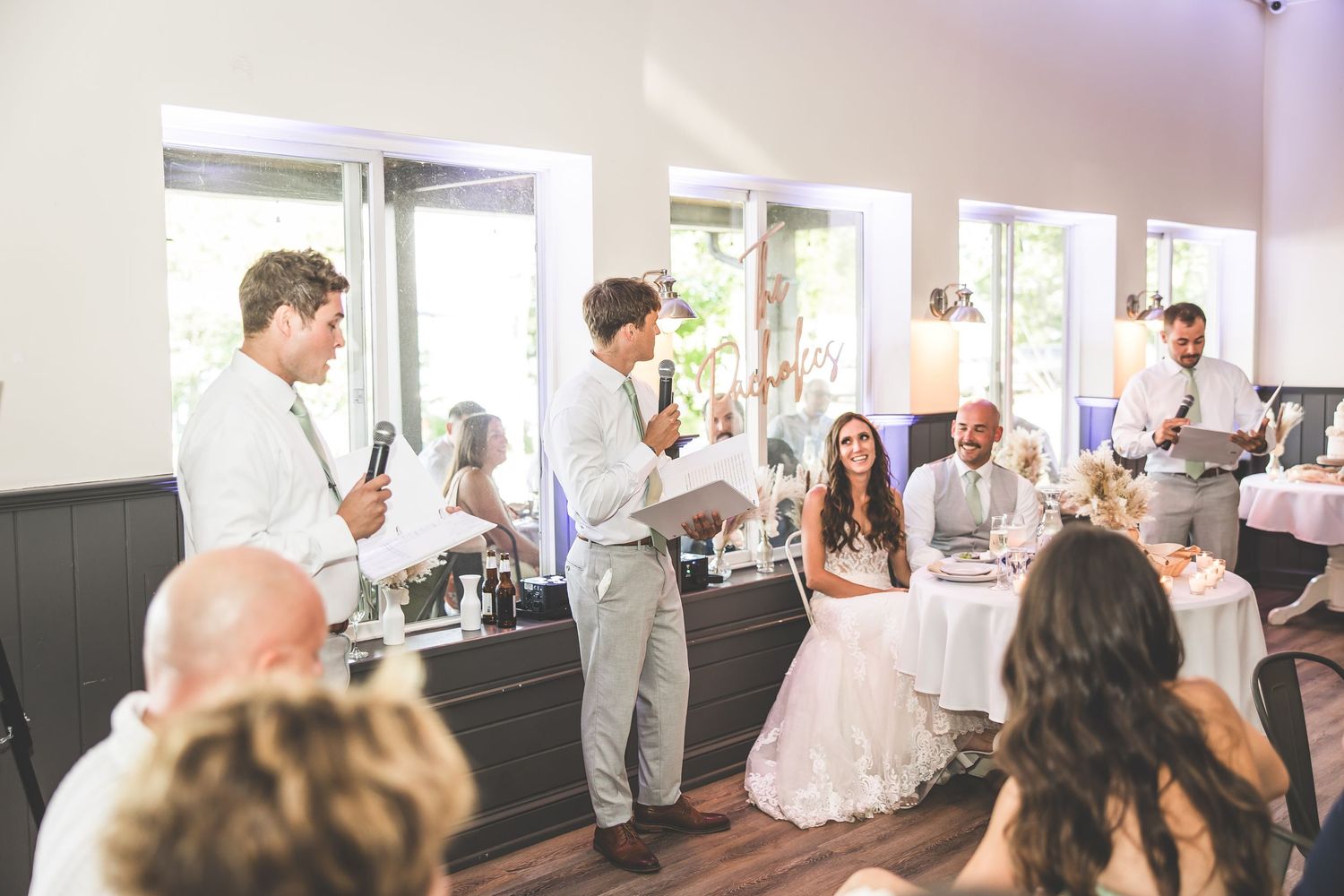 Wedding reception venue with chandelier and large windows creating ambient atmosphere.
