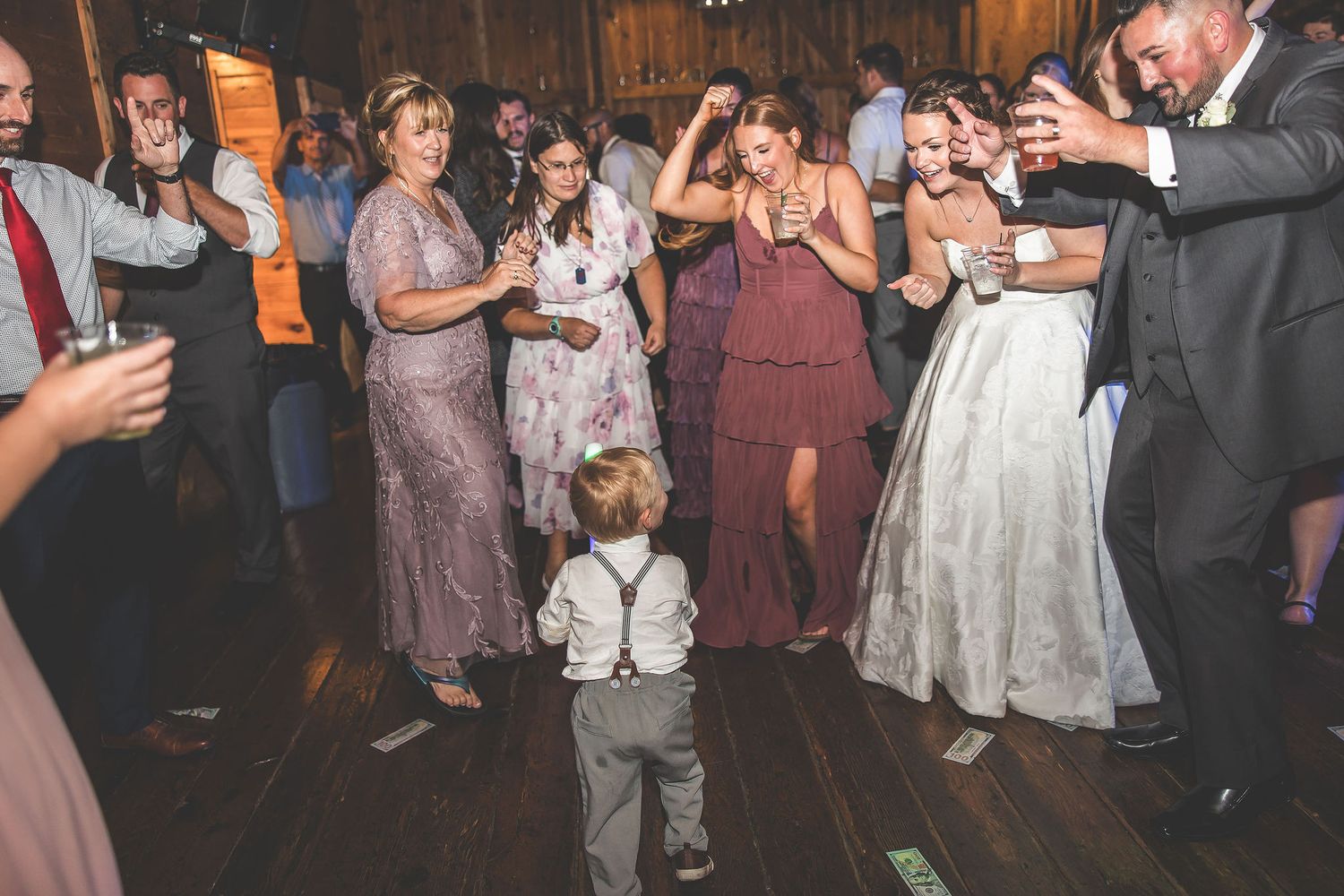 Wedding reception dance party with small child in center of dancing crowd.