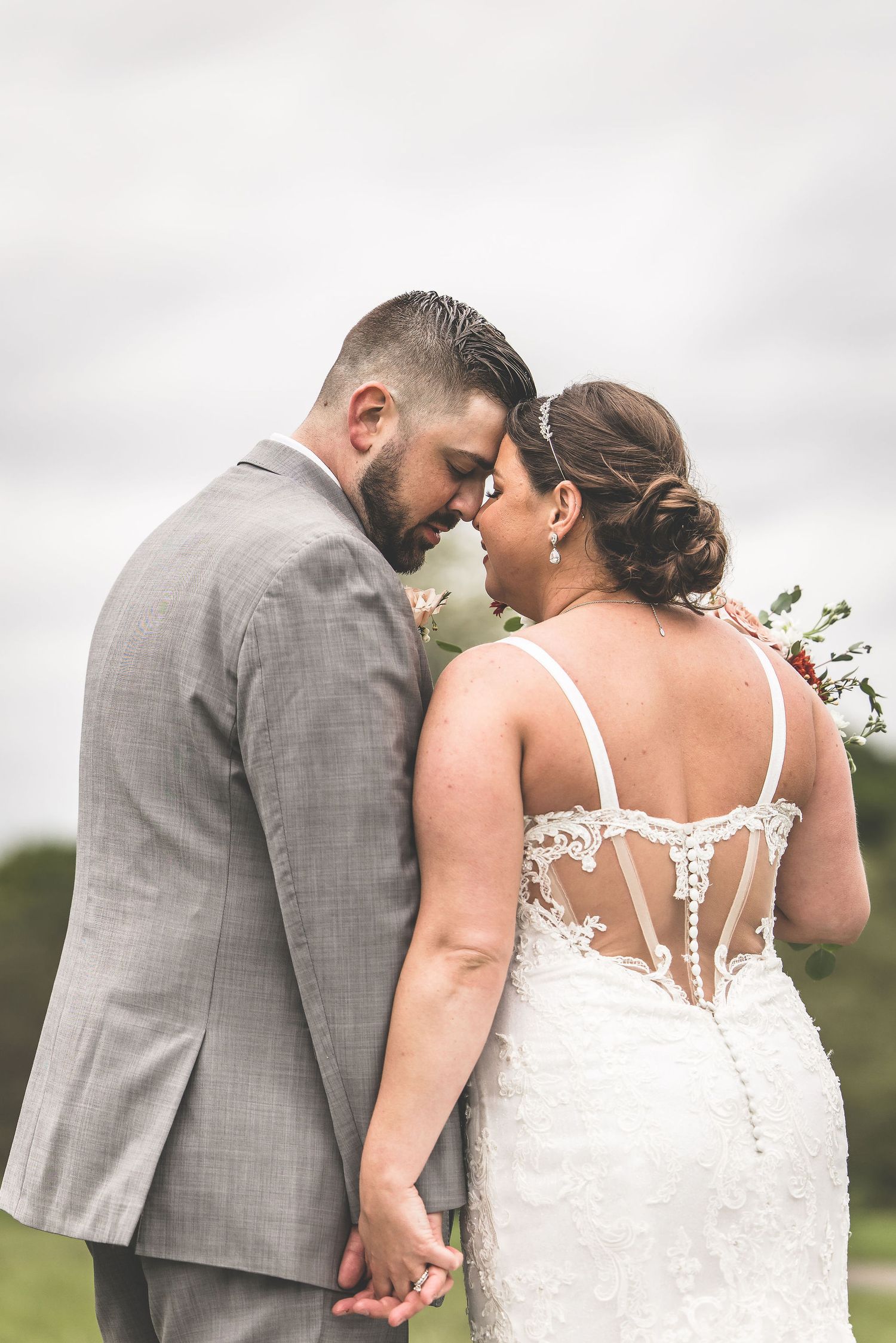 A romantic wedding portrait series showing tender moments between the couple in a grey and white color scheme.