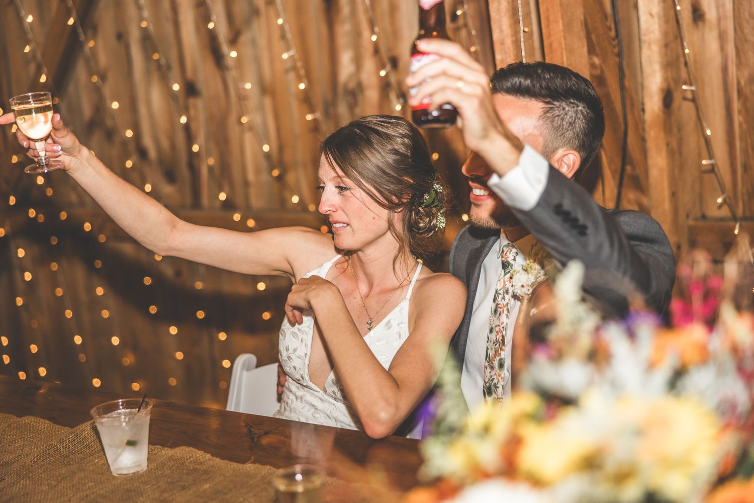 Wedding celebration in barn venue with string lights and festive atmosphere.