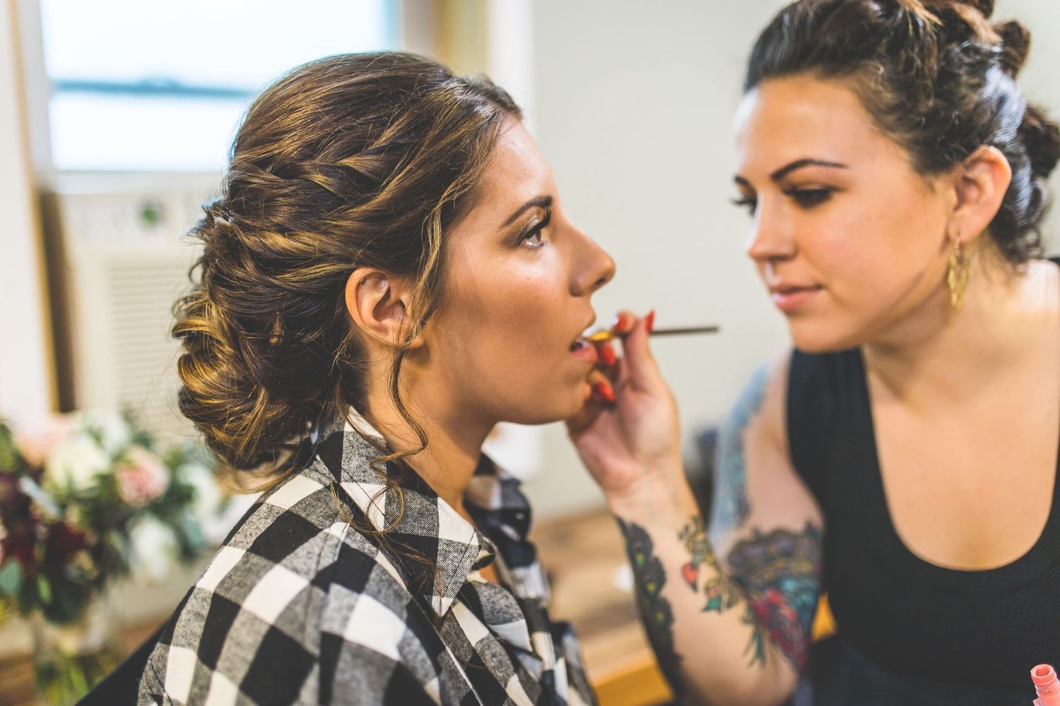 Getting ready moments with bridesmaids in a bright indoor setting.