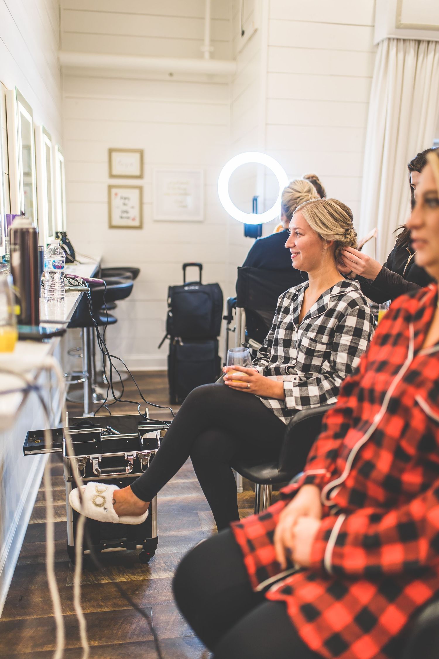 Getting ready scene in a bright salon with red plaid and casual attire.