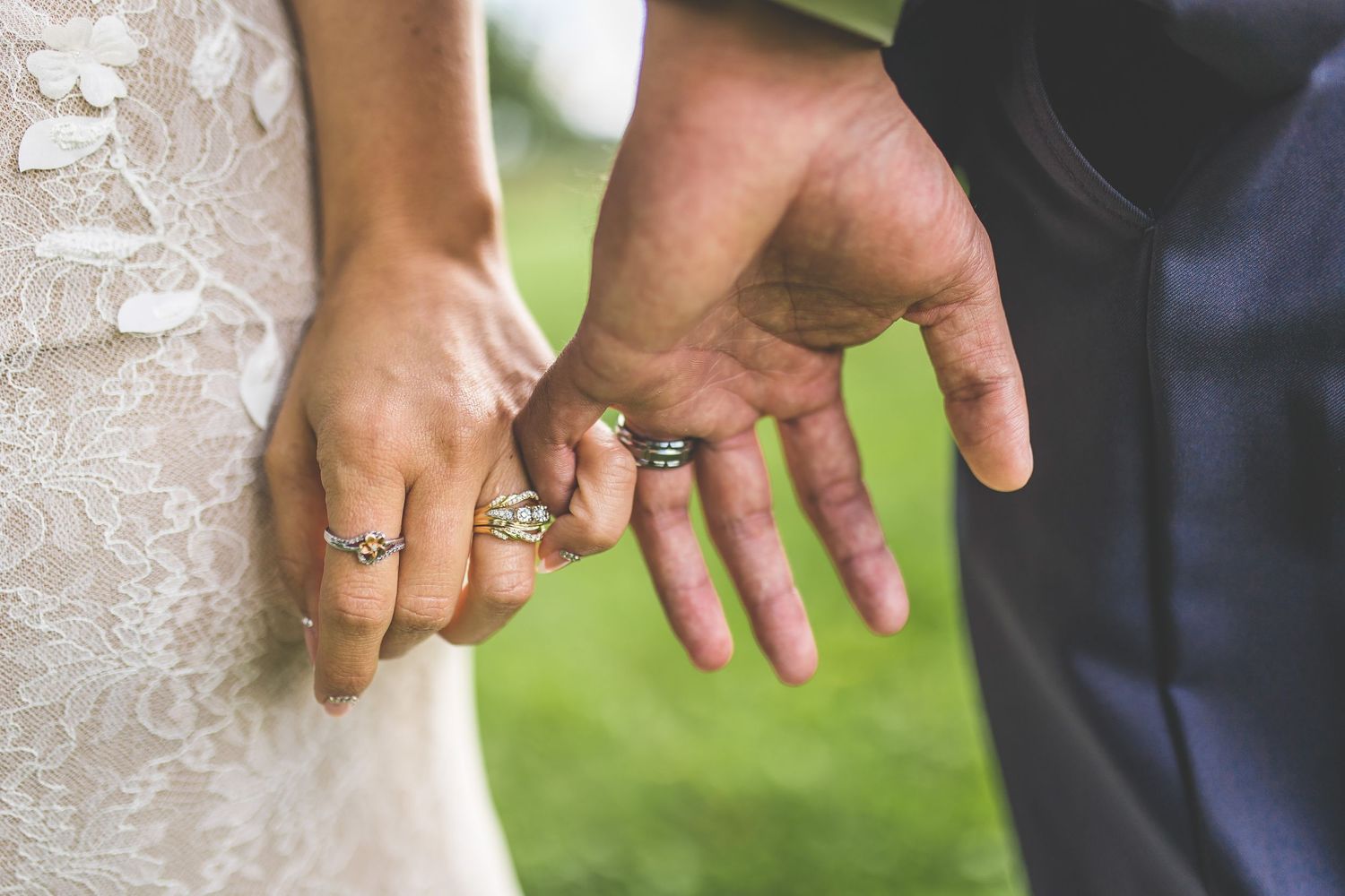 Close-up shots of hands with wedding rings against a light background.