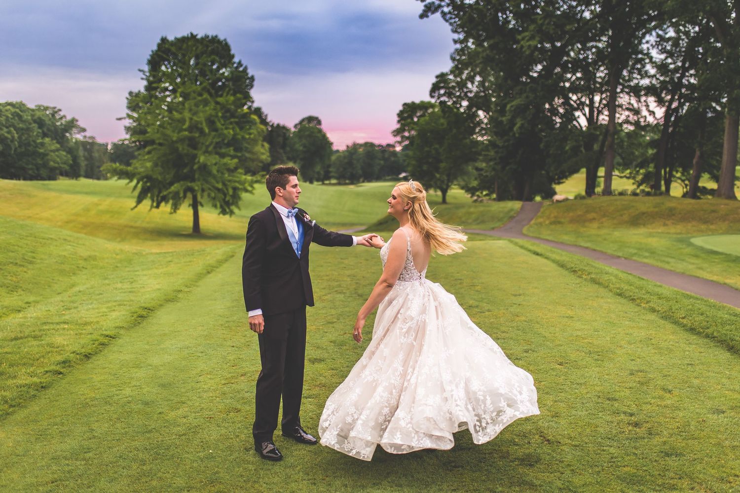 Couple walking across a scenic golf course during their wedding photo session.