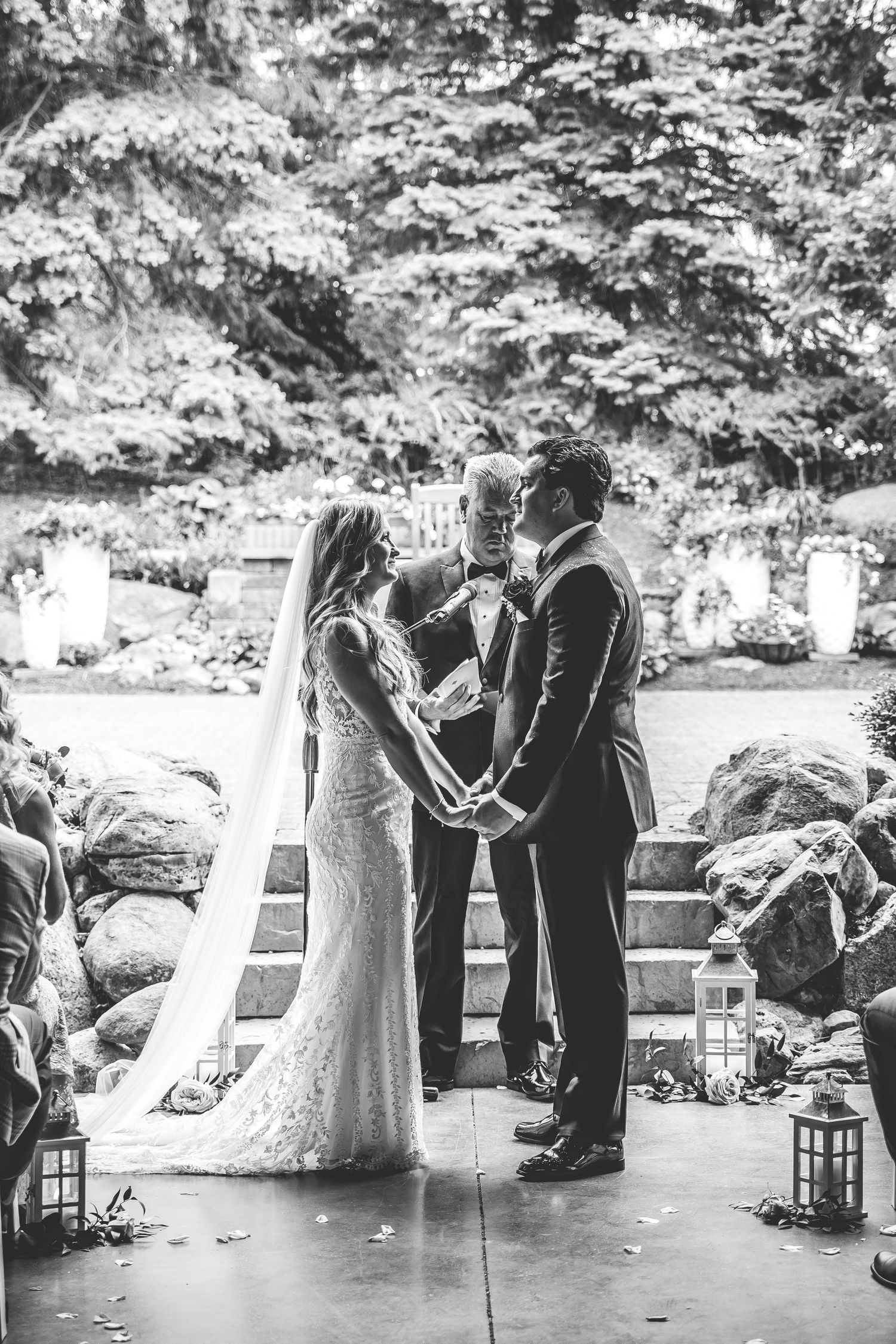 Black and white photo of a wedding ceremony under a covered outdoor space.