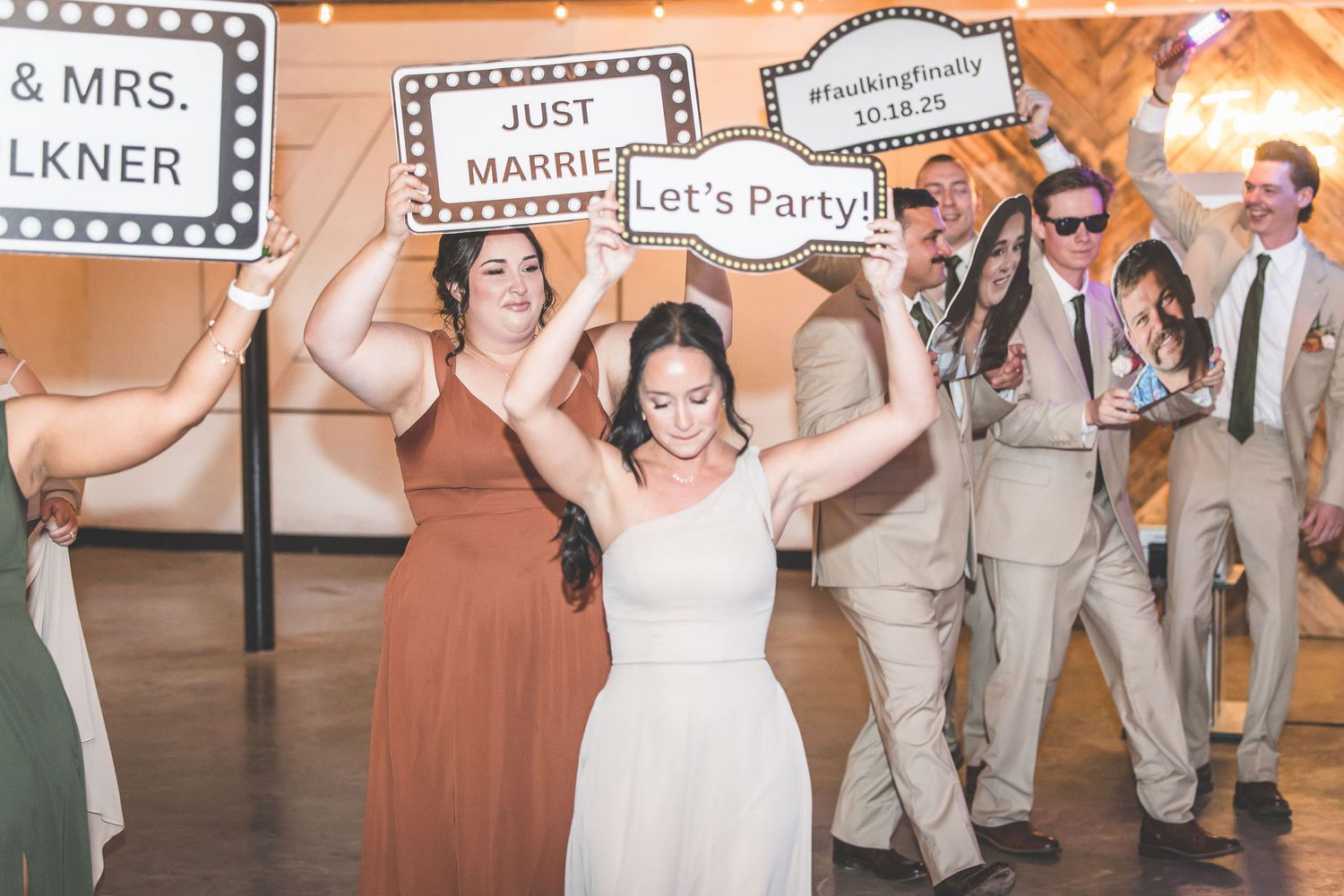 Wedding reception dance floor with celebratory signs and party decorations.