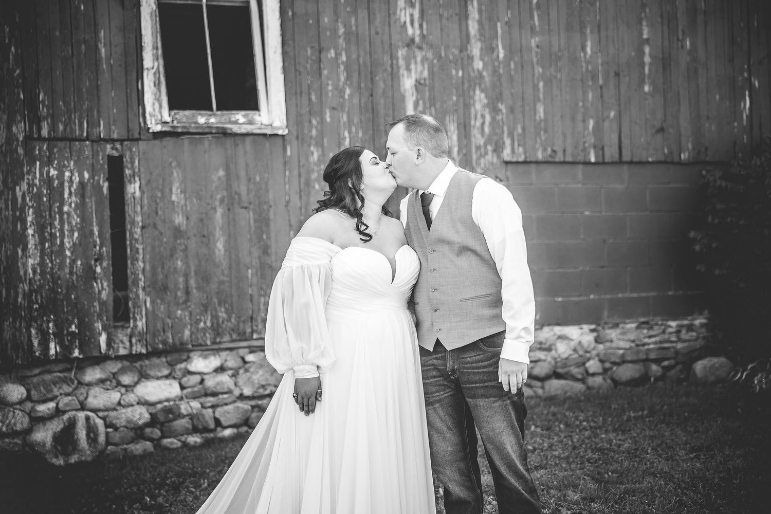 Black and white wedding portrait against vintage barn siding.